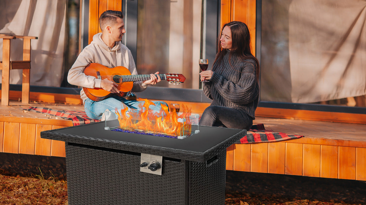 a couple sitting beside the outdoor gas fire pit table