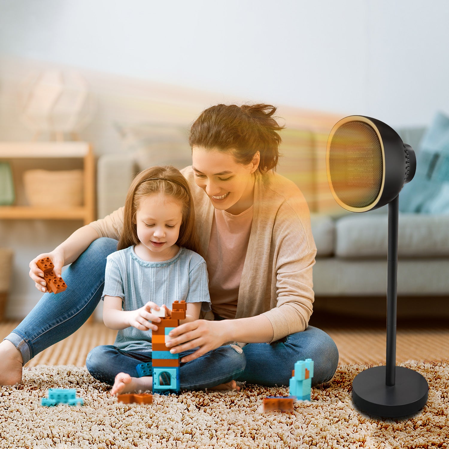 Mother playing with her daughter sitting beside an electric heater