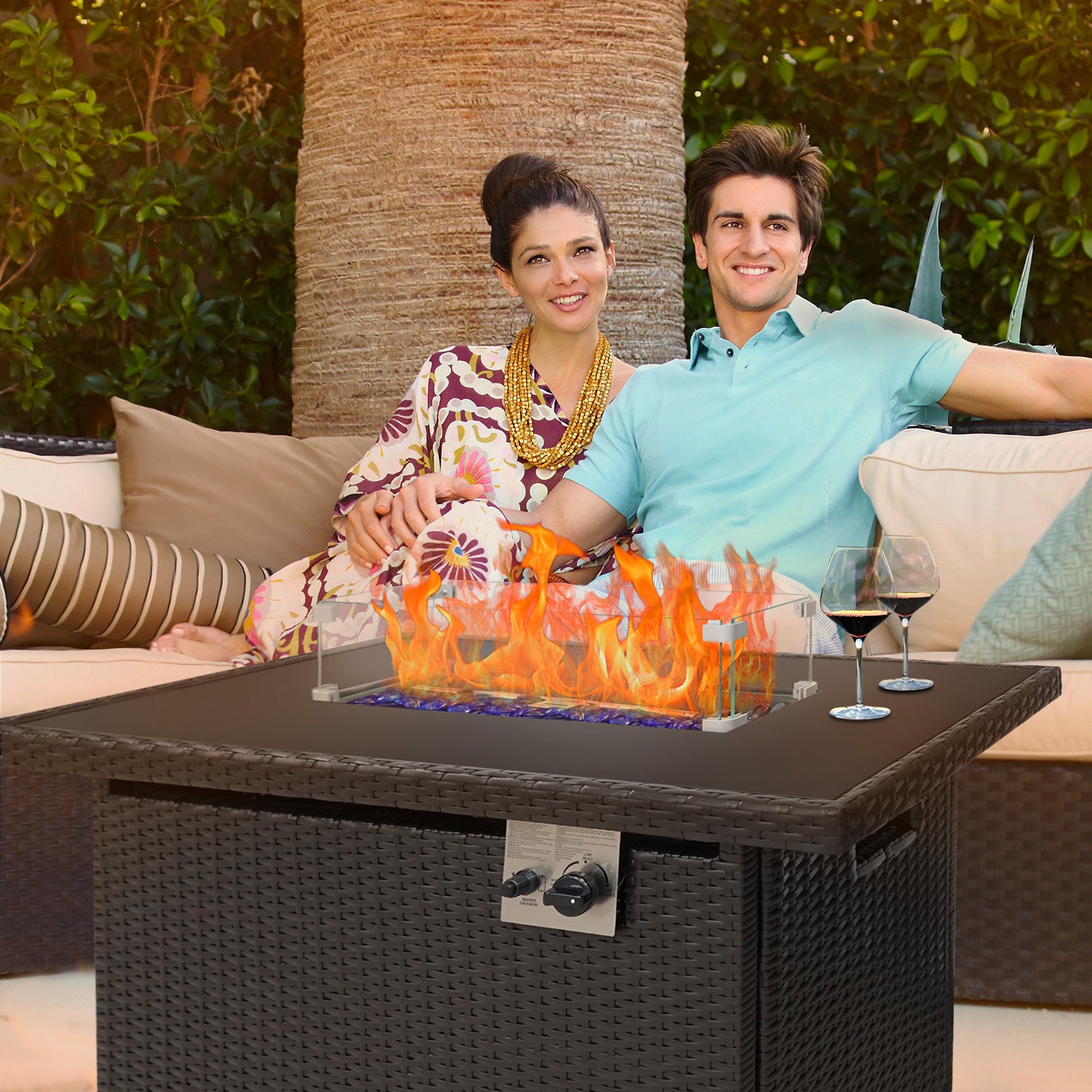 Girl and boy sitting beside the outdoor gas fire pit table